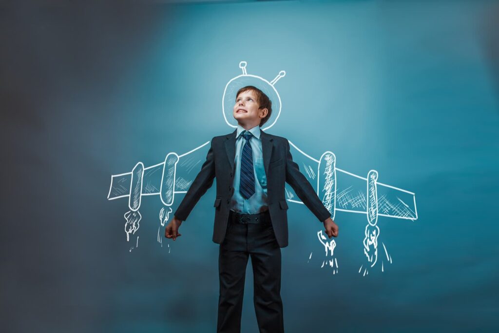 Junge im Anzug mit gezeichneter Raketenflügel-Illustration im Hintergrund – Symbolbild für mentale Stärke und Visualisierung bei Bühnenangst